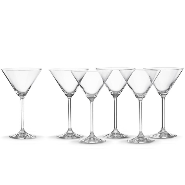 Six empty martini glasses arranged in a row on a white background