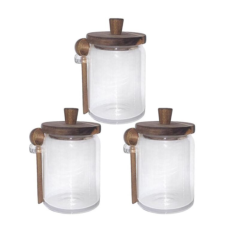 Three glass jars with wooden lids and spoons