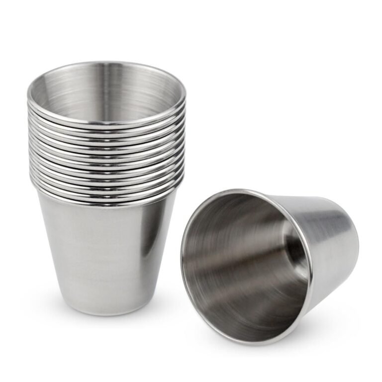 Stack of stainless steel shot glasses, one lying on its side
