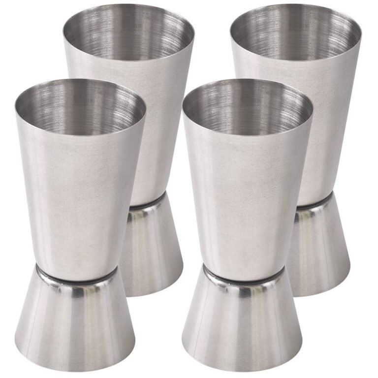 Four stainless steel jigger measuring cups, angled and stacked