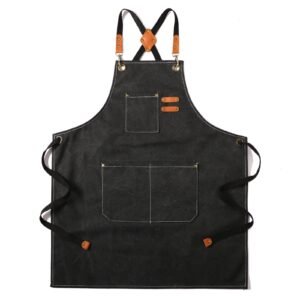 Black apron with leather straps, pockets, and white stitching on a white background