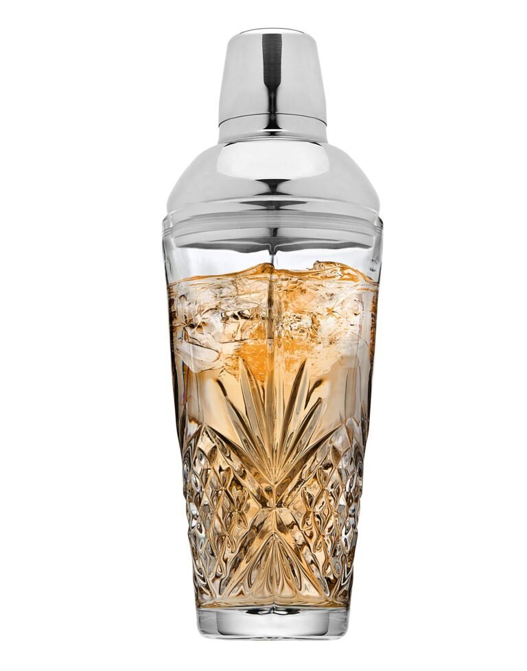 Cocktail shaker with drink and ice, in a decorative, cut-glass container