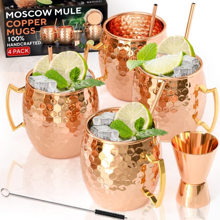 Four copper Moscow Mule mugs with ice, lime, and mint, with accessories