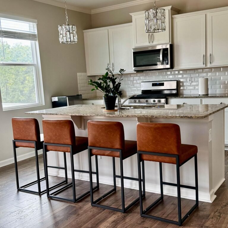 Modern kitchen with island, brown leather bar stools, and crystal chandeliers